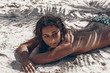 © zolotareva_elina - beautiful young sexy woman lying down on sand beach under palm tree leaf