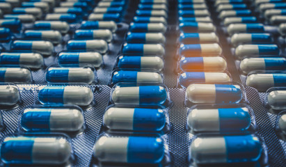 Wall Mural - Blue and white capsules pill in blister pack arranged with beautiful pattern. Global healthcare concept. Antibiotics drug resistance. Antimicrobial capsule pills. Pharmaceutical industry.