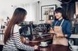 © weedezign - Asia Barista waiter take order from customer in coffee shop,cafe owner writing drink order at counter bar,Food and drink business concept,Service mind concept.