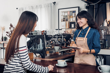 Wall Mural - Asia Barista waiter take order from customer in coffee shop,cafe owner writing drink order at counter bar,Food and drink business concept,Service mind concept.