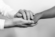 © FocusStocker - Two people holding hands for comfort. Doctor consoling relatives of patients in hospital concept. black and white.