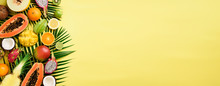 Exotic Fruits And Tropical Palm Leaves On Pastel Yellow Background - Papaya, Mango, Pineapple, Banana, Carambola, Dragon Fruit, Kiwi, Lemon, Orange, Melon, Coconut, Lime. Banner. Top View.