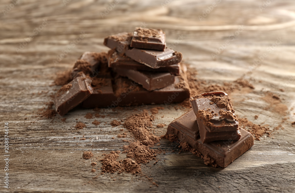 Milk chocolate with cinnamon on wooden background