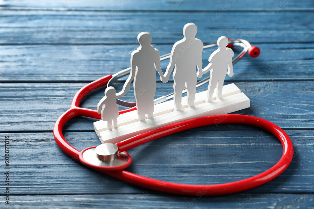 Family figure and stethoscope on wooden background. Health care concept