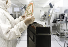 Engineer In White Suits Hands Check The Remaining A Silicon Wafers In Production At Semiconductor Hi Tech Industry, Image Not Focus And Blurred Background
