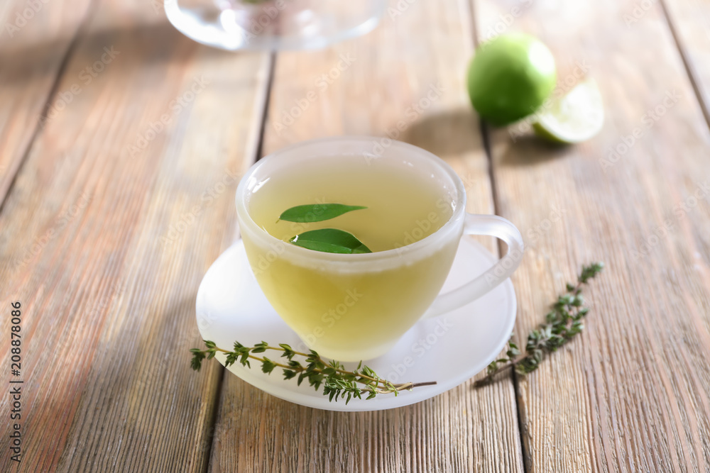 Glass cup of hot aromatic tea on wooden table