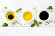 Soy sauce, olive oil and balsamic sauce with herbs basil, parsley, pepper and thyme on white wooden background. Top view.
