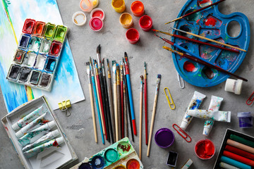 Brushes and paints of professional artist on table