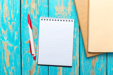 Wall Mural - Top view workspace with blank notebook and pen on wooden table background