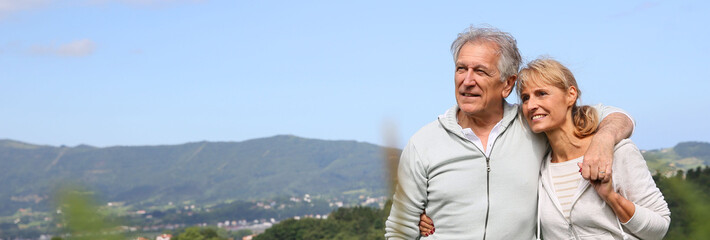 Senior couple walking in countryside, scenery, template