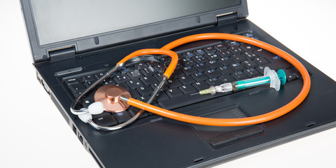 Wall Mural - Workplace of doctor with laptop stethoscope and syringe on white table top view shot