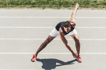 Wall Mural - young sportsman exercising on running track at sport playground