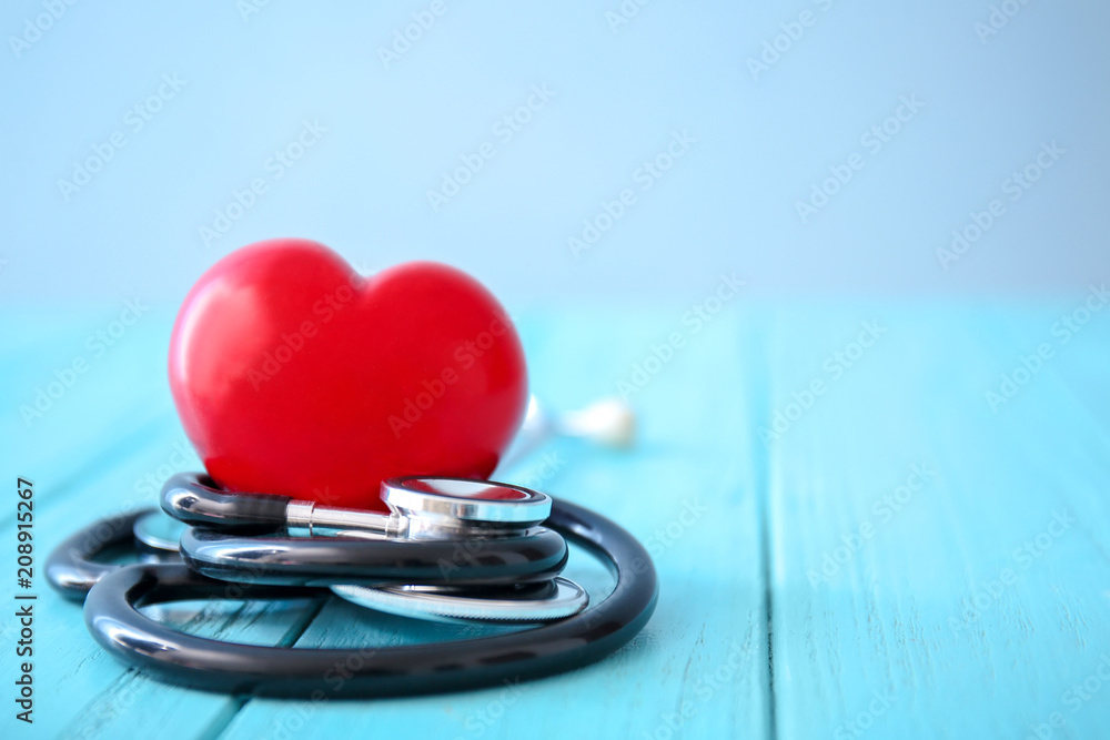 Medical stethoscope with heart on wooden table. Health care concept