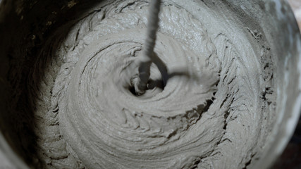 Bucket with gray mortar mixing and blending for working on site