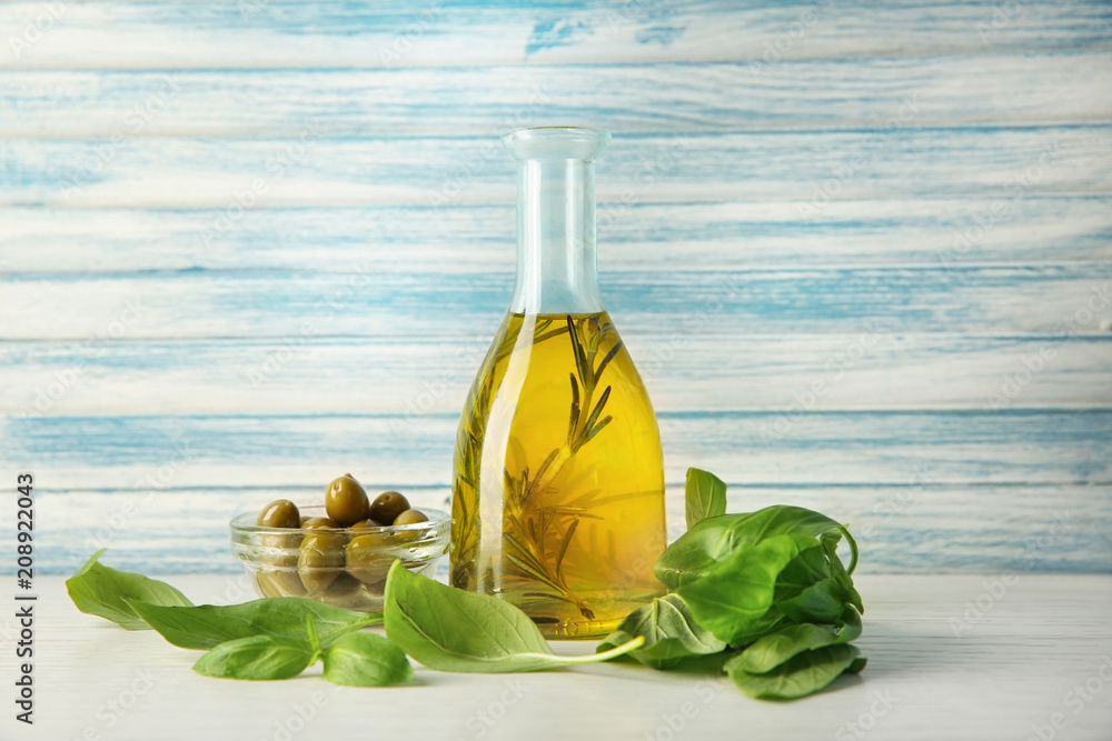 Bottle with oil and olives on wooden table