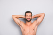 Attractive, stunning, manly, smiling macho isolated on gray background, having two arms behind the head and closed eyes, showing his shaven armpits - wellness, wellbeing concept