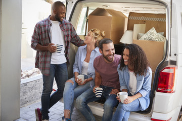 Wall Mural - Friends Helping Couple To Unload Removal Truck On Moving Day