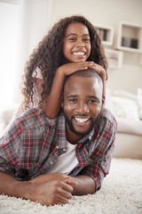 Wall Mural - Portrait Of Daughter Lying On Fathers Back In Lounge