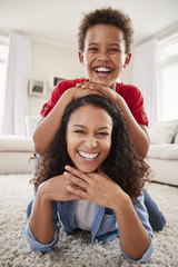 Canvas Print - Portrait Of Son Lying On Mothers Back In Lounge