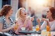 © ivanko80 - Three happy young woman chatting in cafe