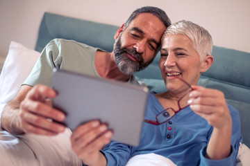 Wall Mural - Happy mature couple using digital tablet