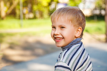 portrait of a happy smiling boy who walks in the street