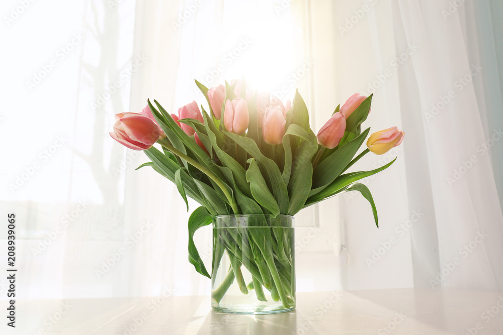 Vase with beautiful tulips on windowsill