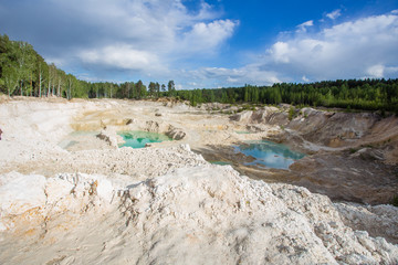 Open pit quarry ore white kaoline mining with blue sky and water