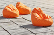 Three coloroful orange beanbags chairs for relaxing outdoor