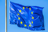 Fototapeta  - Flag of Europe blue color with yellow stars waving in the wind on blue sky.