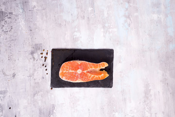 Wall Mural - Raw salmon filet on dark slate cutting board. Lean proteins.