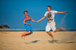 © Vladimir - Man and woman have fun jumping on the beach