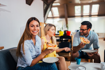 Wall Mural - Happy business team eating pizza in the office.