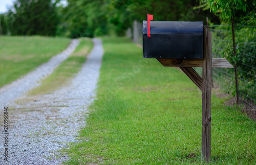 Fotomural Rural mailbox with flag raised along a gravel road.