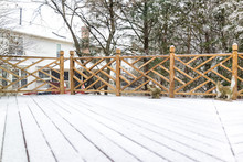 Empty Wooden Deck Of House With Statue Decorations On Backyard In Neighborhood With Snow Covered Wood Floor During Blizzard White Storm, Snowflakes Falling In Virginia Suburb
