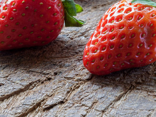 Close-up macro of a pair of strawberries on cracked wooden cutting table