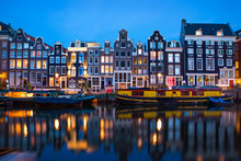 Amsterdam Canal  With Typical Dutch Houses And Houseboats At Evening With Beautiful Water Reflections, Holland, Netherlands. 