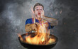 © TheVisualsYouNeed - shocked messy man with apron holding pan in fire burning the food in kitchen disaster and unskilled and unexperienced terrible home cook