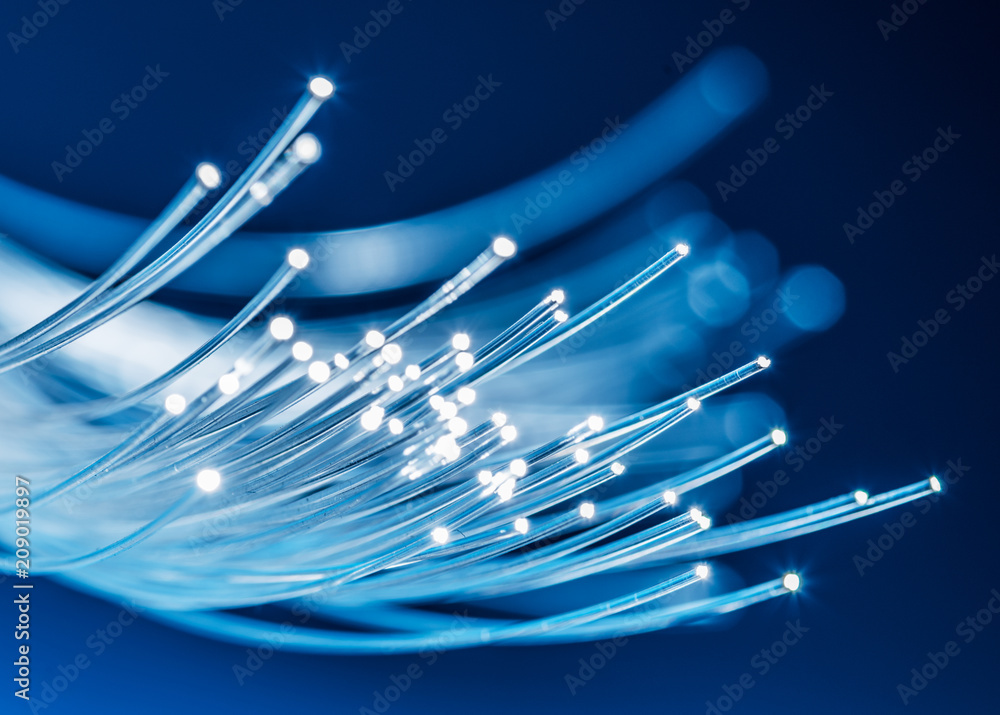 Bundle of optical fibers with lights in the ends. Blue background. - obrazy, fototapety, plakaty 