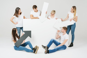 Group of friends with a white sign and arrows