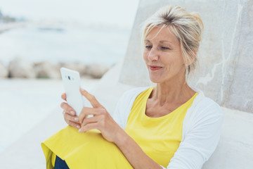 Wall Mural - Attractive blond woman reading a phone message