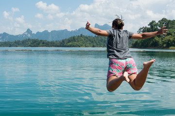 Young people jumping into a lake.