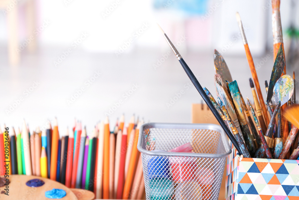 Artist's tools with paints on blurred background