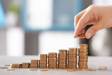 Woman stacking coins on table