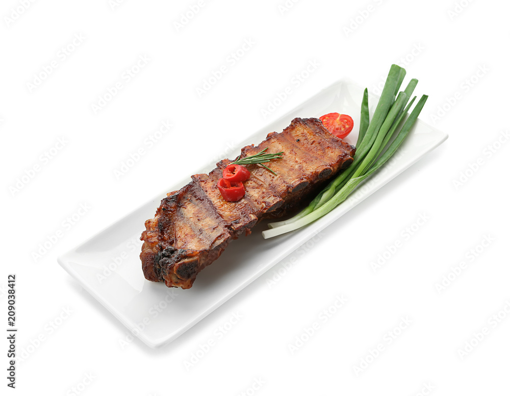 Plate with delicious grilled ribs and green onion on white background