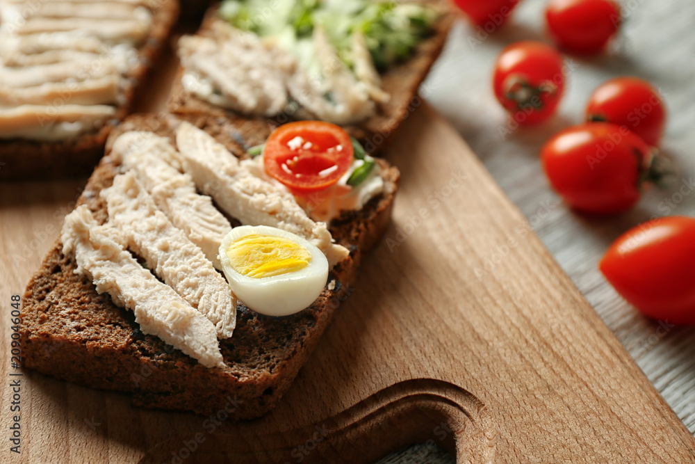 Delicious toast with meat and egg on board, closeup