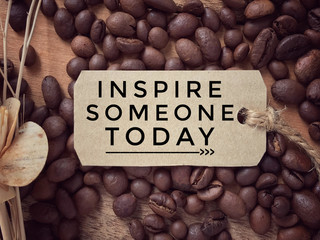 Motivational and inspirational quote - ‘Inspire someone today’ written on a piece of paper. With vintage styled background.