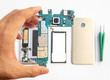 Close-up of technician holdinging smartphone logic boardon blurred smartphone component background