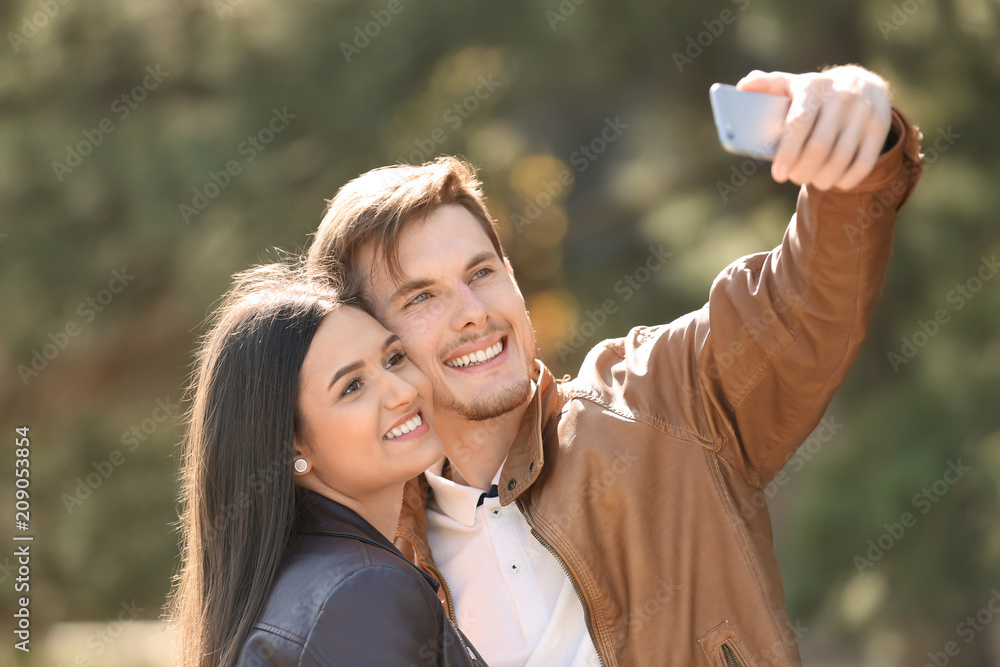 Young lovely couple taking selfie outdoors