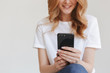 © Drobot Dean - Cropped image of young redhead woman using mobile phone.